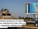 A U.S. military vehicle drives past a poster showing Syrian President Bashar al-Assad. AP Photo/Baderkhan Ahmad, File